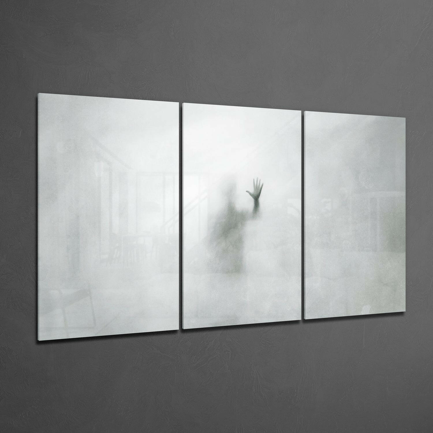 Three-panel frosted glass wall art displaying a blurred silhouette of a raised hand against white and gray tones.