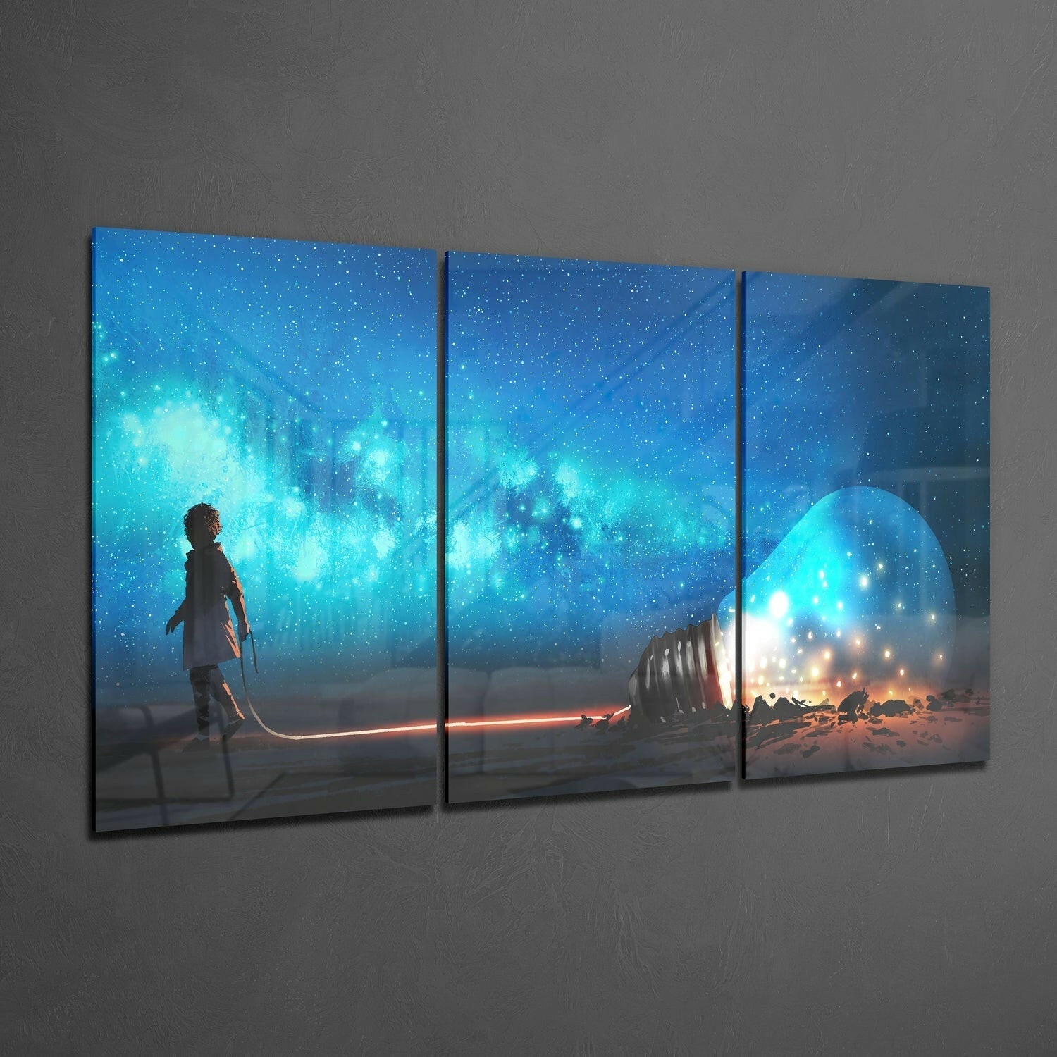 Three-panel glass wall art displaying a child standing beneath a starry blue sky with glowing turquoise nebula and illuminated light bulb structure on desert landscape.