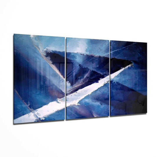 Three-panel blue glass wall art depicting snow-covered mountain valleys with white slopes and deep blue shadows.