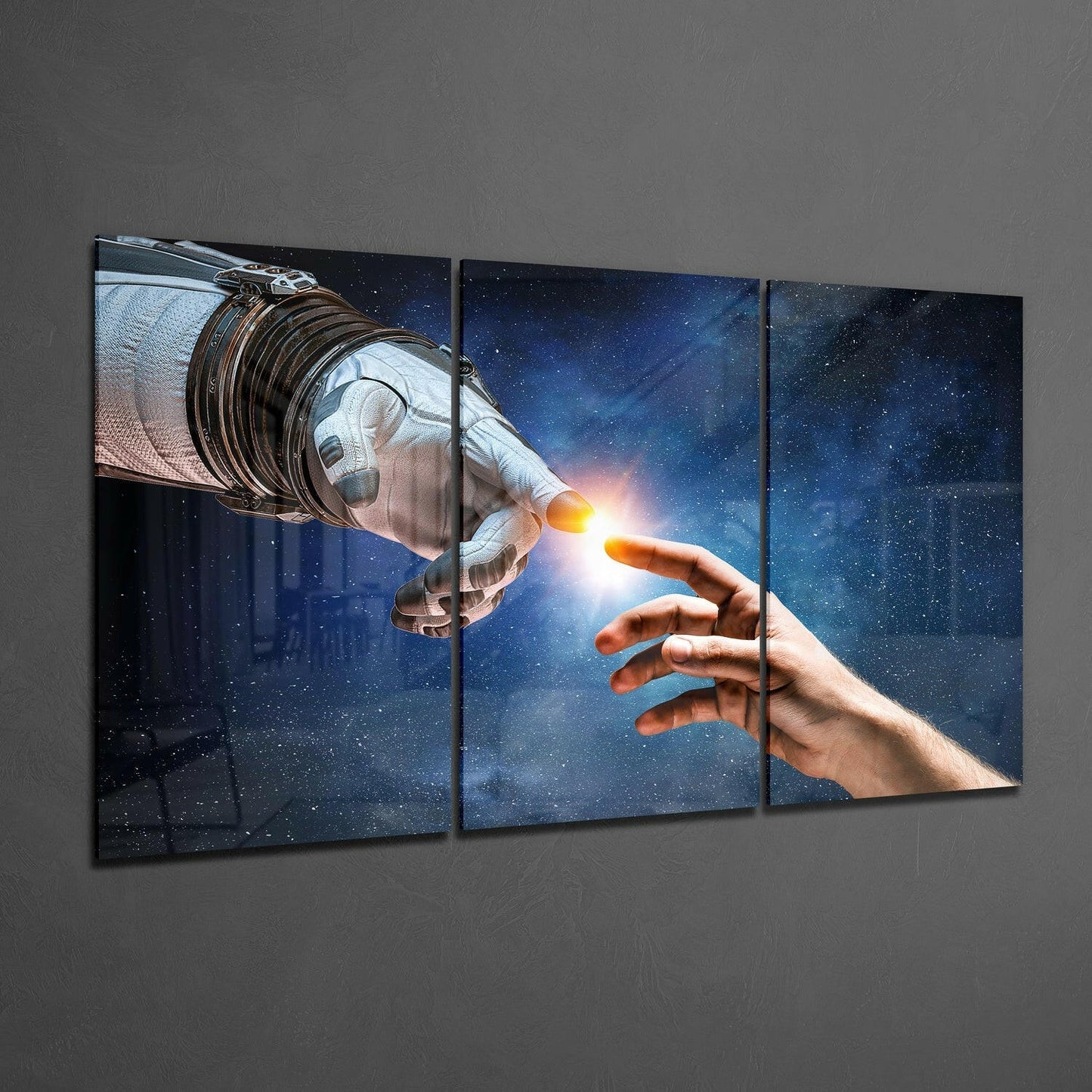 Three-panel glass wall art displaying an astronaut's gloved hand touching a human hand against a starry blue space background.