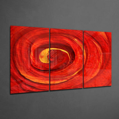 Three-panel red glass wall art displaying concentric glowing circles in red and yellow tones on gray wall.