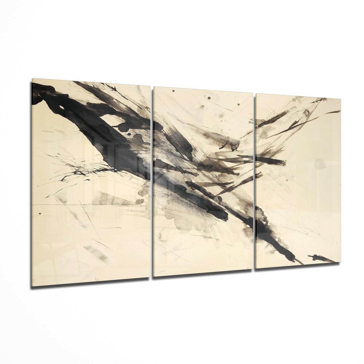 Three-panel glass wall art with abstract black brushstrokes and charcoal marks on cream background, displayed at angle.