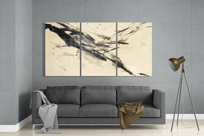 Three-panel cream and black abstract glass wall art hung above gray sofa in modern living room interior.