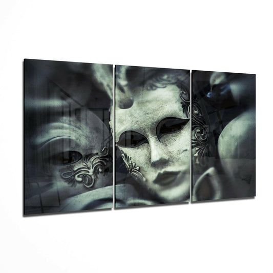 Three-panel glass wall art displaying ornate Venetian carnival masks in pale gray and black tones with decorative baroque details.