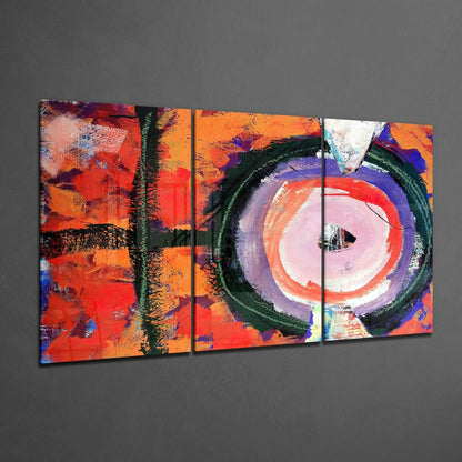 Three-panel glass wall art displaying abstract composition with vibrant red, orange, purple, and green brushstrokes and circular motifs against gray wall.