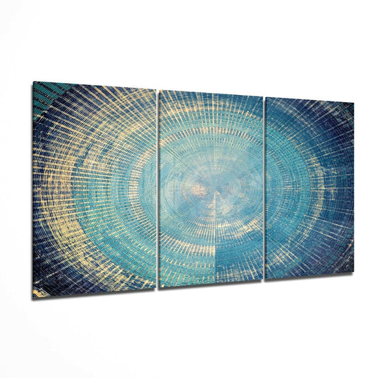 Three-panel glass wall art displaying concentric circular patterns in blue, teal, and gold tones radiating from center.
