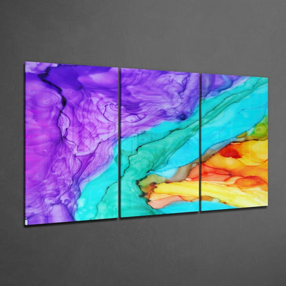 Three-panel glass wall art displaying swirling purple, turquoise, yellow, and orange ink patterns against gray background.