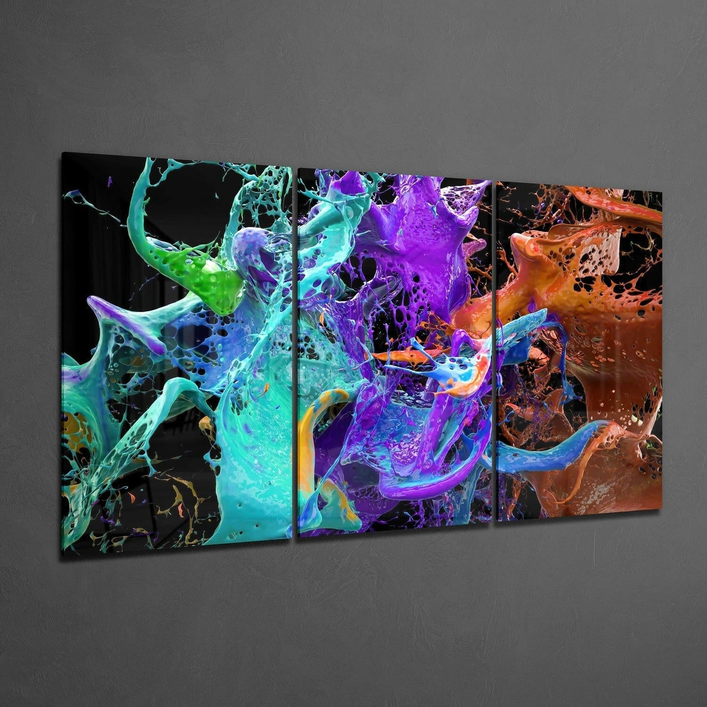 Three-panel glass wall art displaying vibrant splashing liquids in cyan, purple, and orange against black backgrounds, mounted on gray wall.