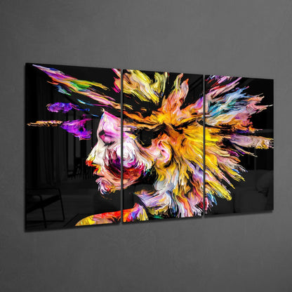 Multi-panel glass wall art displaying an abstract colorful portrait with vibrant brushstrokes in yellow, pink, purple, and orange on black background.