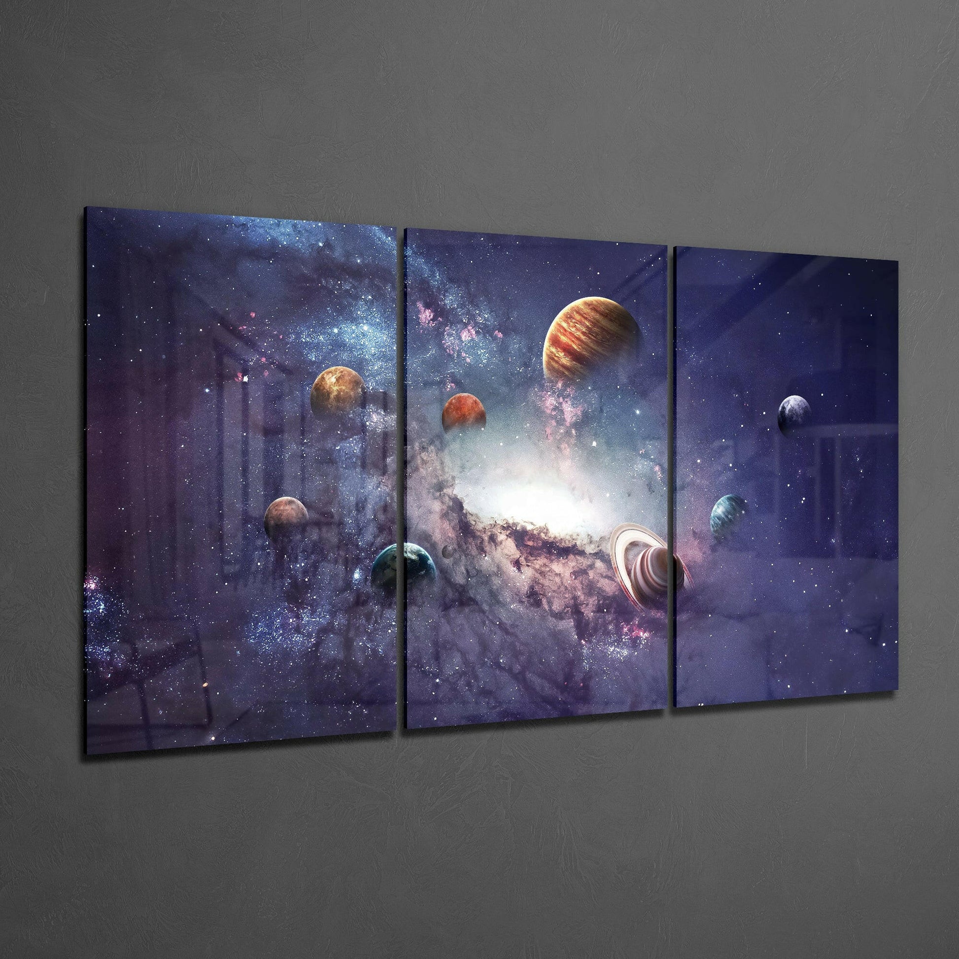Three-panel glass art displaying planets and galaxy against deep purple starfield on gray wall.