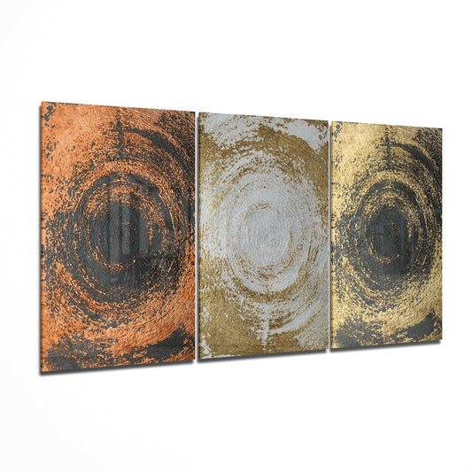 Three glass panels displaying concentric circles in copper, silver, and gold metallic finishes on dark backgrounds, arranged side by side.