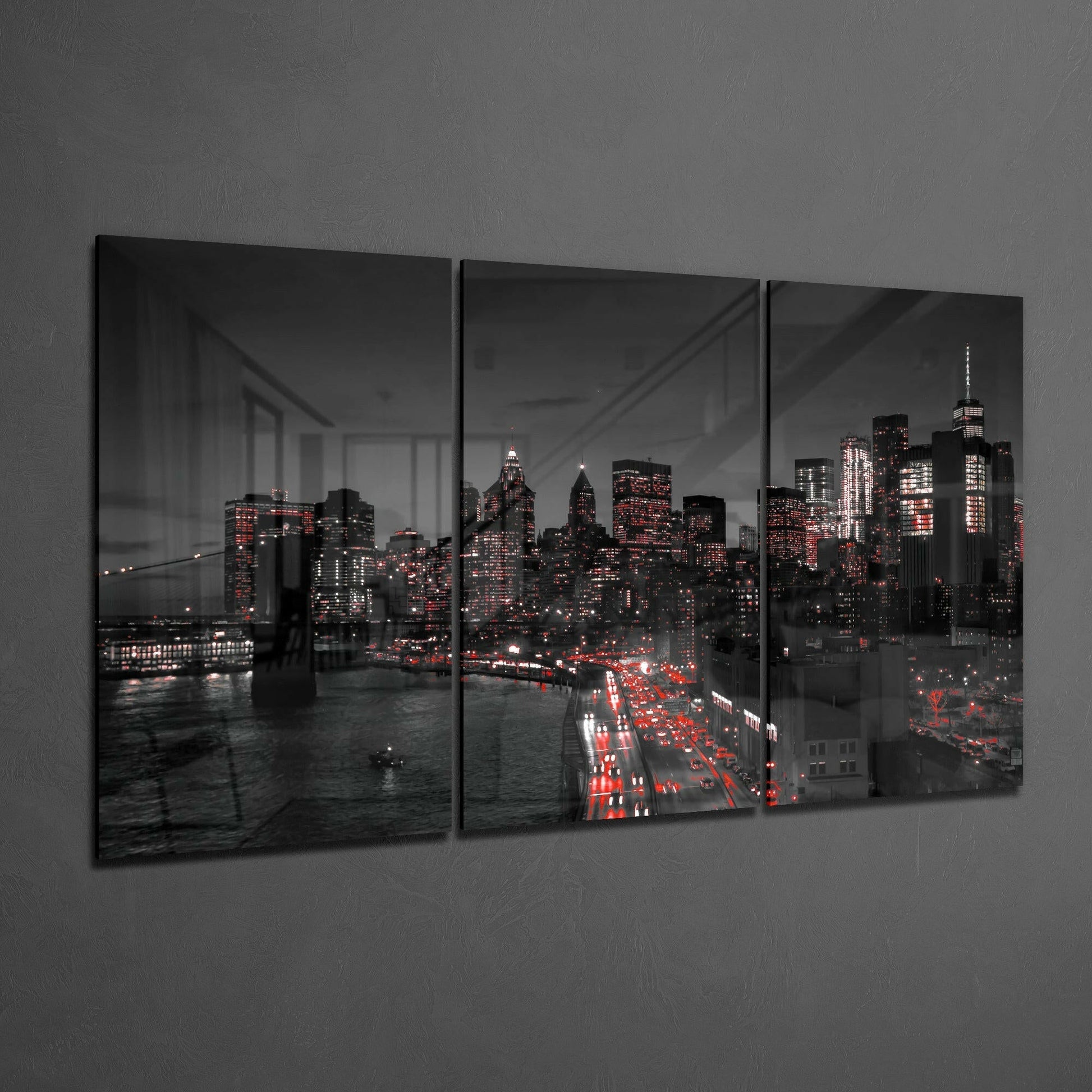 Three-panel glass art displaying nighttime Manhattan skyline with illuminated skyscrapers, Brooklyn Bridge, and red traffic lights against gray wall.