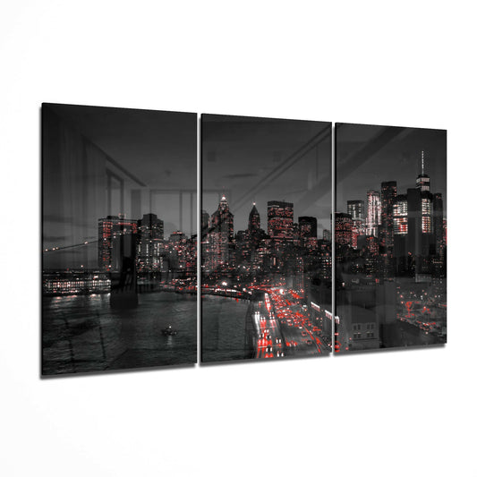 Three-panel black glass art displaying illuminated New York City skyline with red vehicle lights and Brooklyn Bridge at night.