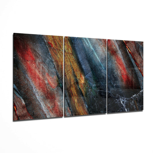 Three-panel glass art displaying layered diagonal stripes in red, blue, gold, and black with textured surfaces.