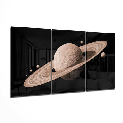 Three-panel glass art displaying a beige planet with rings and smaller moons against a black background with interior reflection.