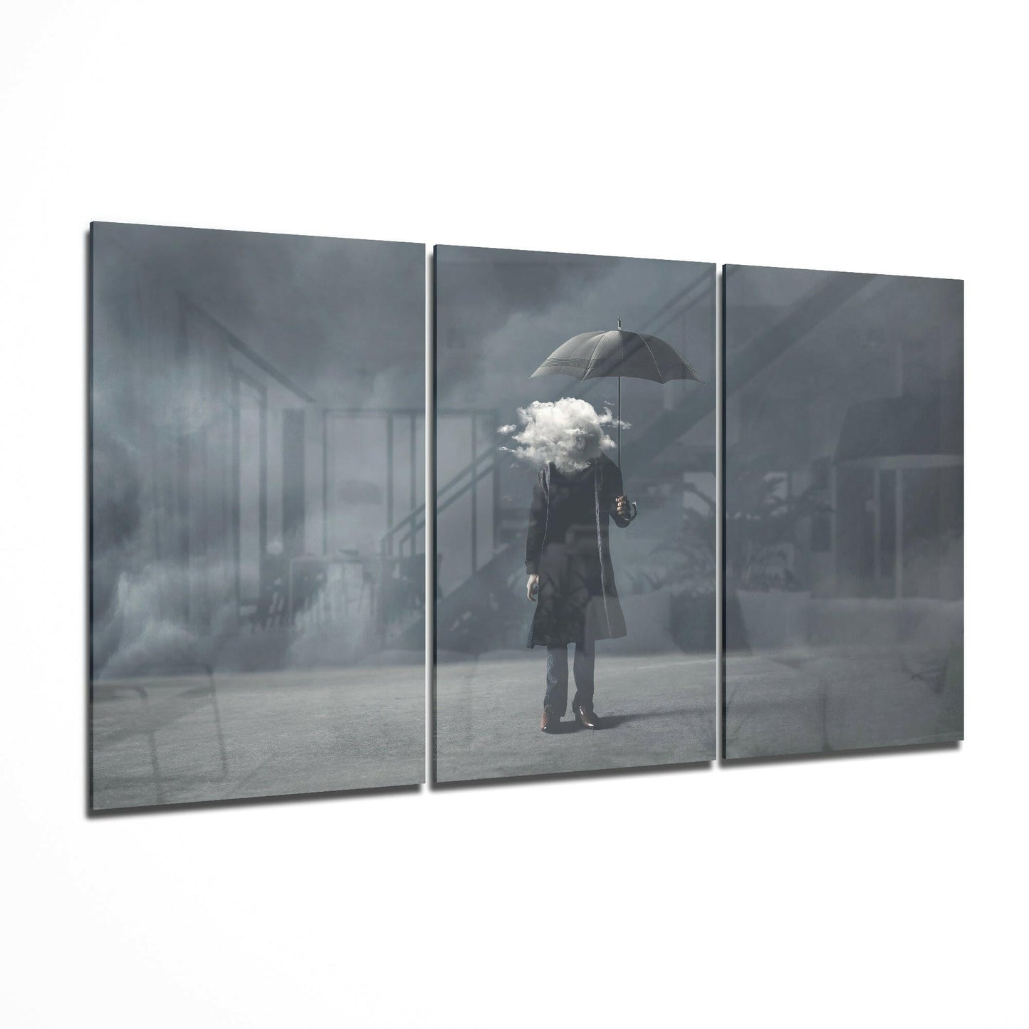 Three-panel glass art display showing a figure holding an umbrella with a white cloud where the head should be, set against a gray urban background.