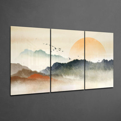 Three-panel glass art depicting misty mountains, an orange sun, and birds in flight against a cream sky.