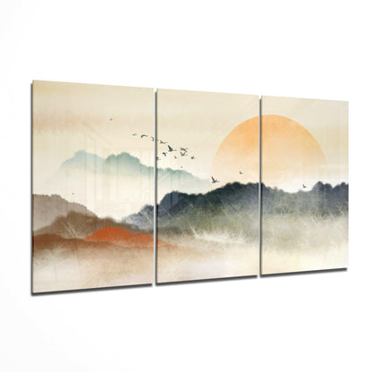 Three-panel glass art depicting misty mountains with golden sun, flying birds, and layered landscape in soft earth tones.