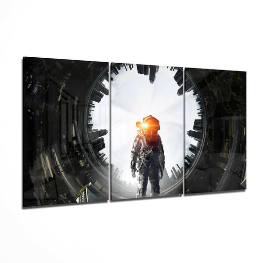 Three-panel glass art displaying a astronaut in spacesuit centered between dark urban cityscapes with glowing orange light.