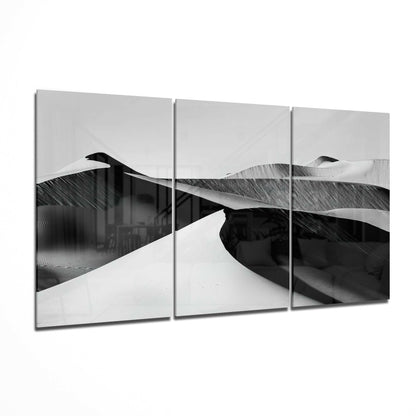 Three-panel black and white desert landscape glass art displaying rolling sand dunes with dramatic shadows and highlights.