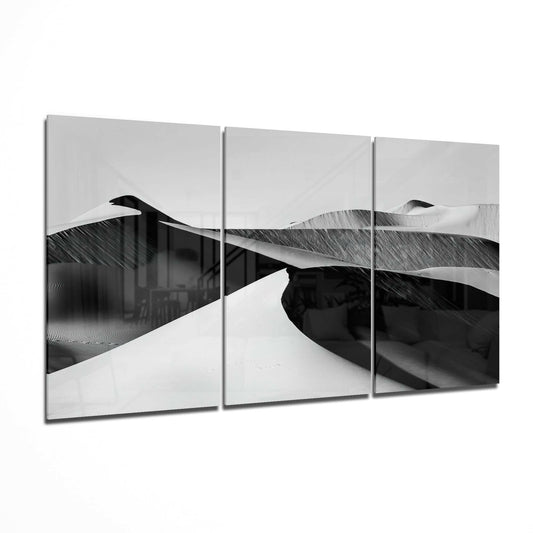 Three-panel black and white desert landscape glass art displaying rolling sand dunes with dramatic shadows and highlights.