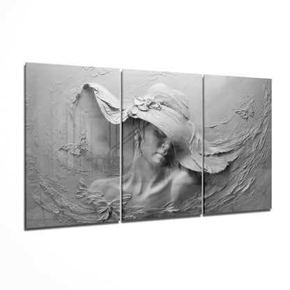 Three-panel grayscale glass art depicting a woman wearing a wide-brimmed hat with flowing fabric and floral details.