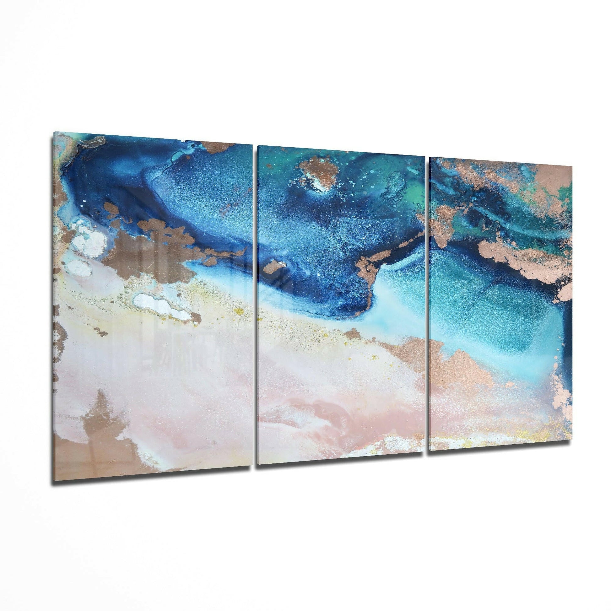 Three-panel glass art depicting an aerial coastal view with turquoise water, sandy beach, and bronze-toned landmasses.