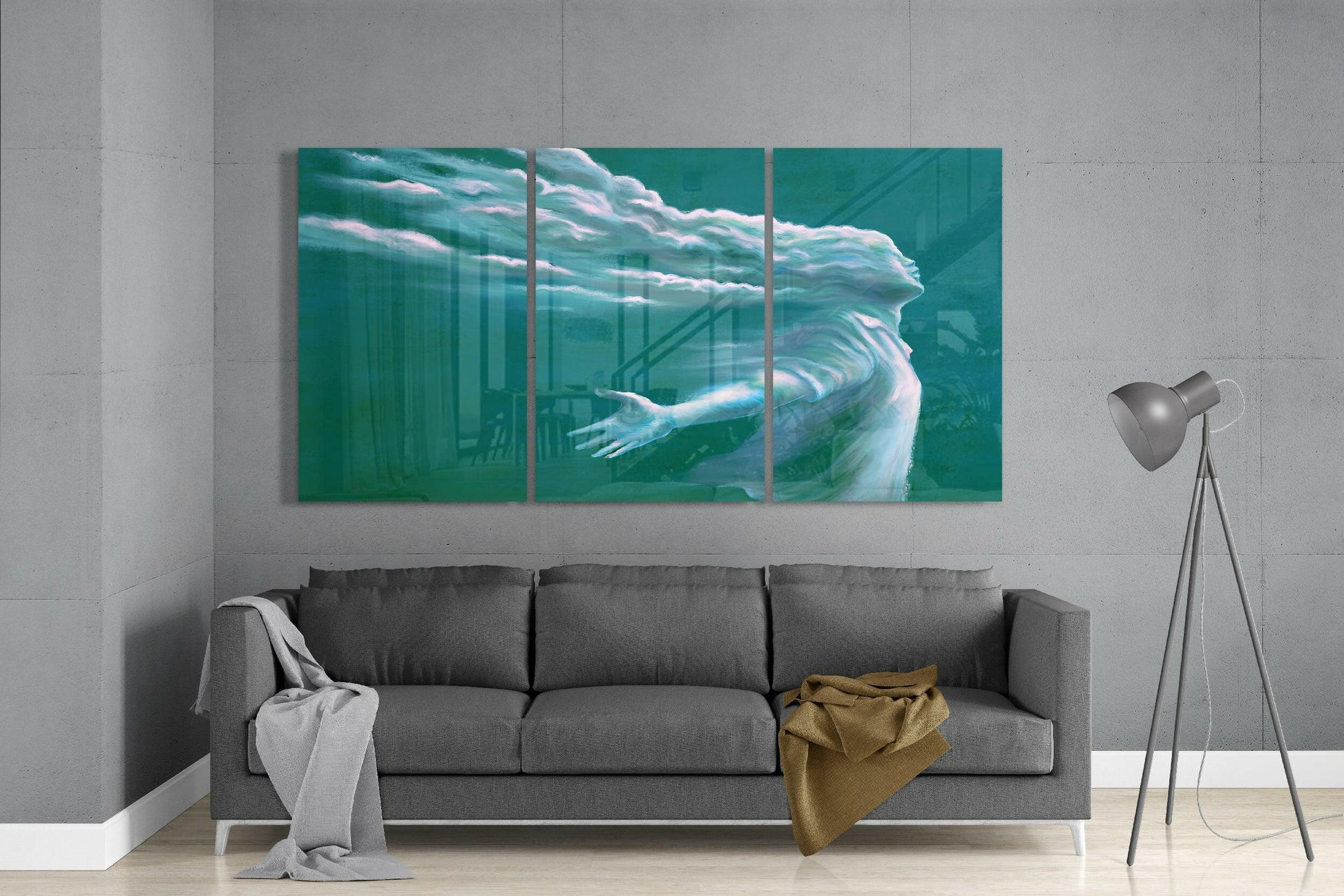 Three-panel turquoise glass art depicting an ethereal figure with flowing hair and outstretched arm, displayed above gray sofa.