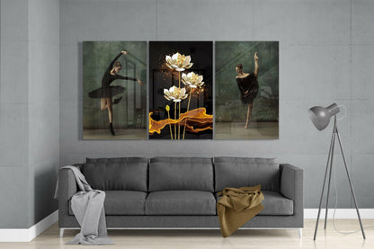 Three glass art panels displayed above gray sofa: left and right show ballerinas in black dresses, center features gold lotus flowers on black background.