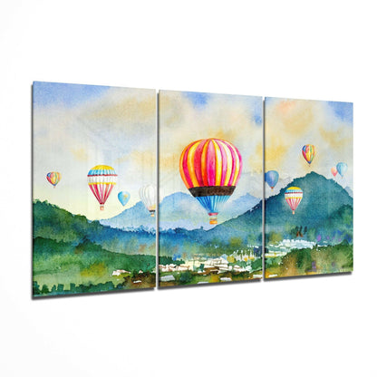 Three-panel glass art depicting colorful hot air balloons floating over green mountains and a valley town under a blue sky.