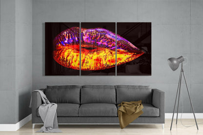 Vibrant neon glass lip sculpture with red, yellow, purple and blue colors displayed above gray sofa in modern living room.