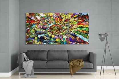 Three-panel vibrant stained glass art with radiating multicolored mosaic pattern displayed above gray sofa in modern living room.