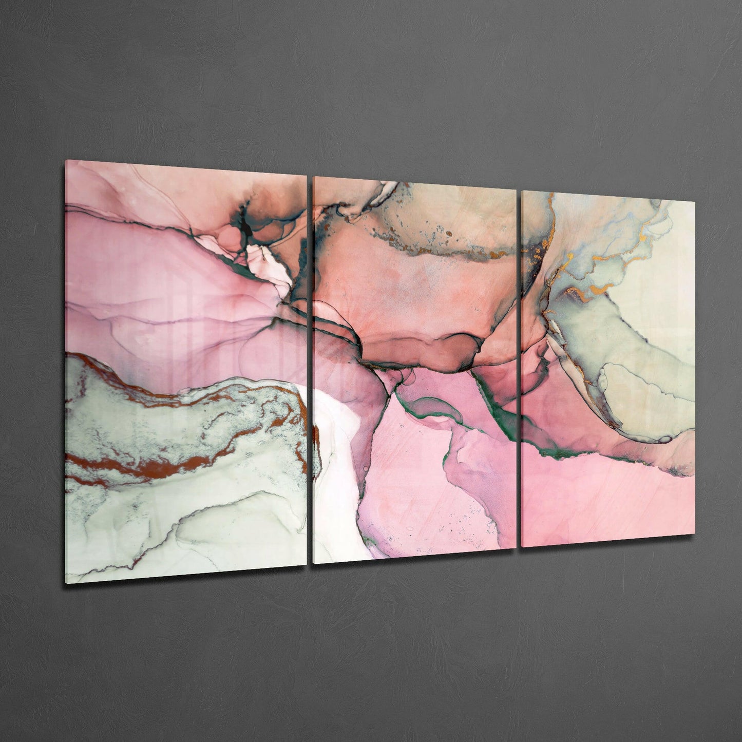 Three-panel pink glass art with fluid abstract design featuring cream, rose, and sage tones with dark line details, displayed at an angle against gray wall.