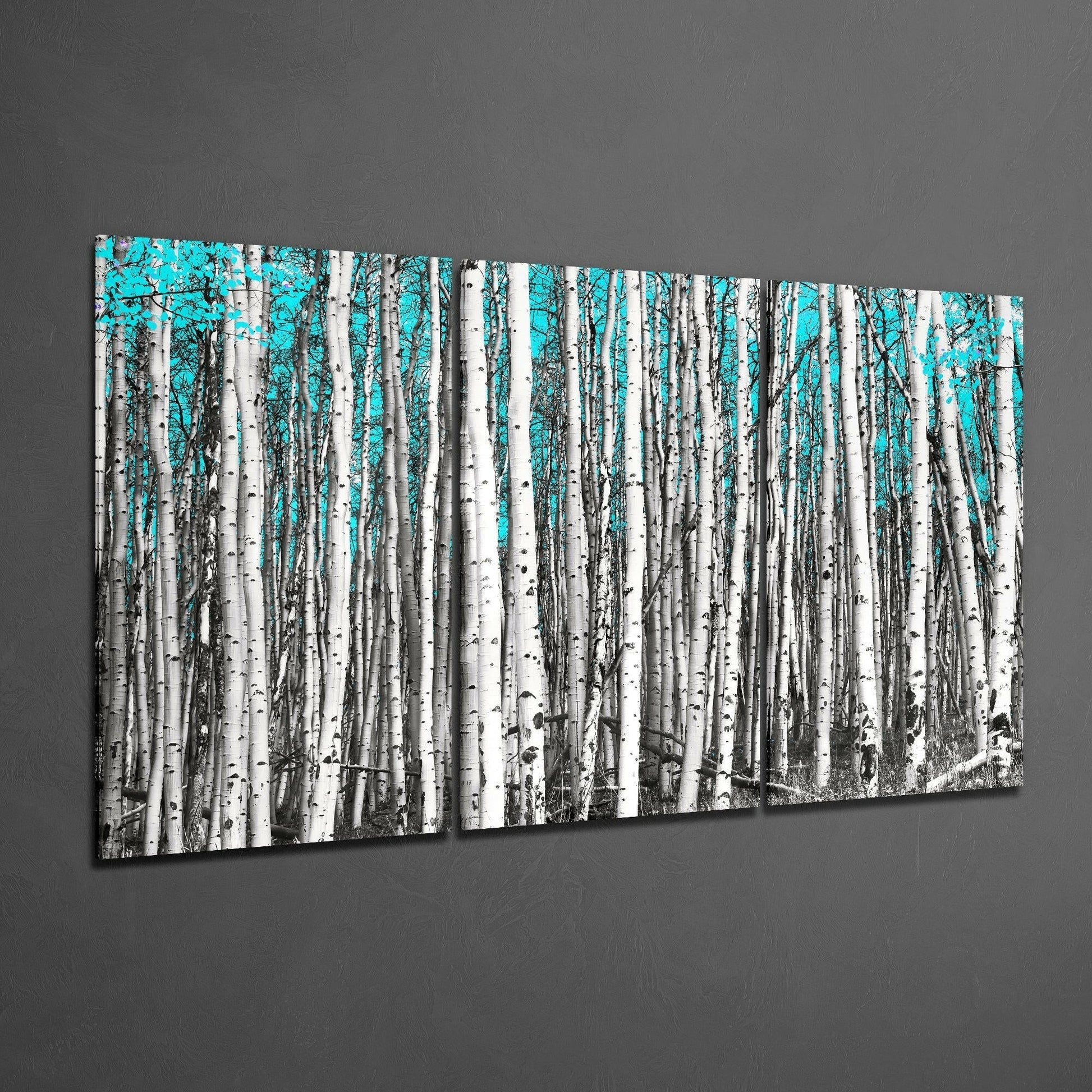 Two-panel birch forest glass art with white tree trunks and bright turquoise sky, displayed at angle on gray wall.
