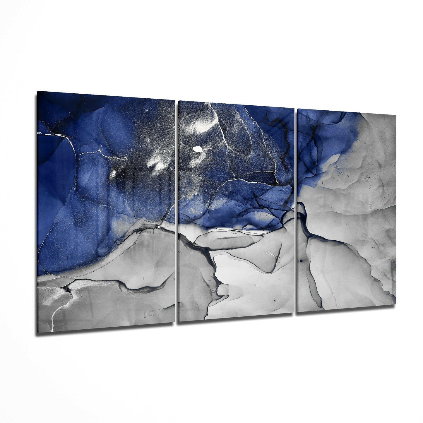 Three-panel glass art with deep blue swirling patterns and white metallic accents transitioning to grey-white lower sections, displayed at an angle.