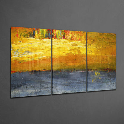 Three-panel abstract glass art with yellow, orange, and blue horizontal color blocks displayed on gray wall.