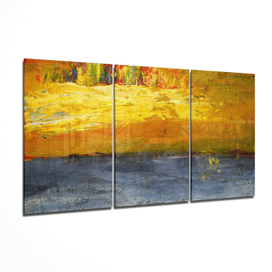 Three-panel abstract glass art with vibrant yellow upper sections transitioning to dark blue-gray lower sections, displaying textured brushstroke patterns and warm color gradients.