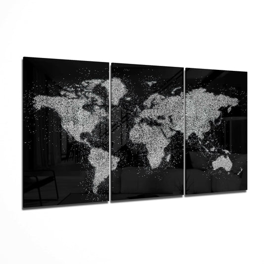 Three-panel glass wall art displaying a world map made of white paint splatters on black background, angled perspective view.