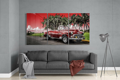 Three-panel red classic car glass art displayed above gray sofa in modern living room interior.