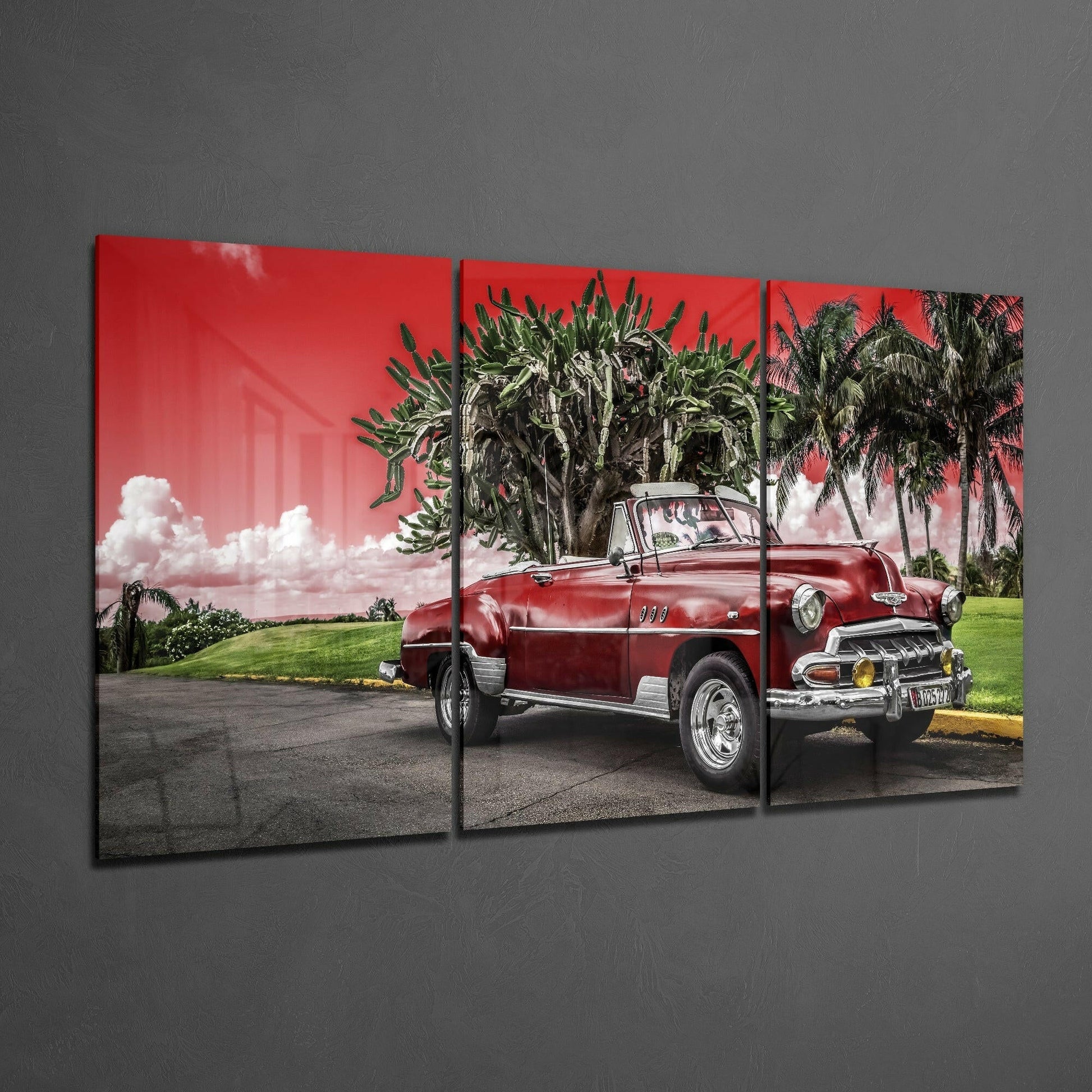 Three-panel glass art displaying a red vintage convertible car parked beneath palm trees against a pink sky.