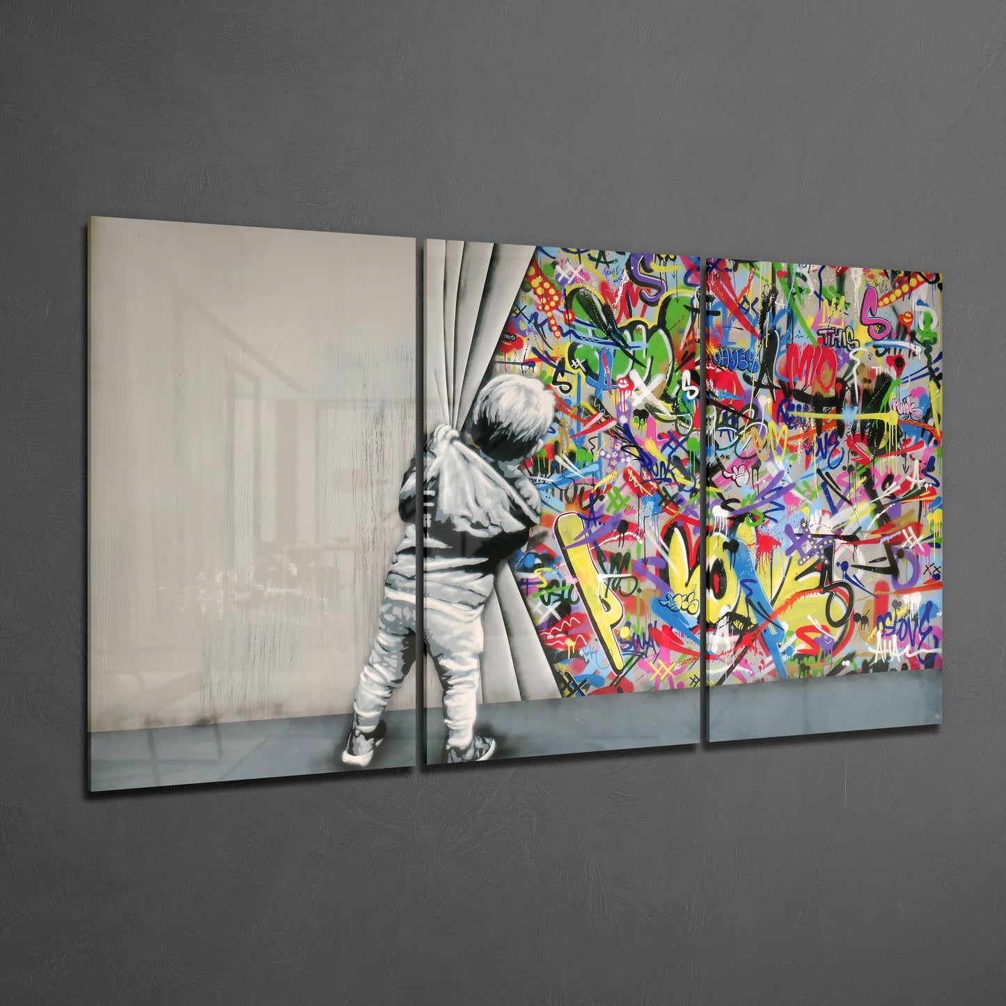 Three-panel glass wall art showing a child pulling back curtains to reveal vibrant multicolored graffiti, displayed at an angle against gray wall.