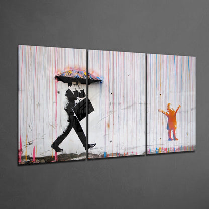 Three-panel glass wall art displaying black and white figures with colorful umbrellas and paint drips on striped background.
