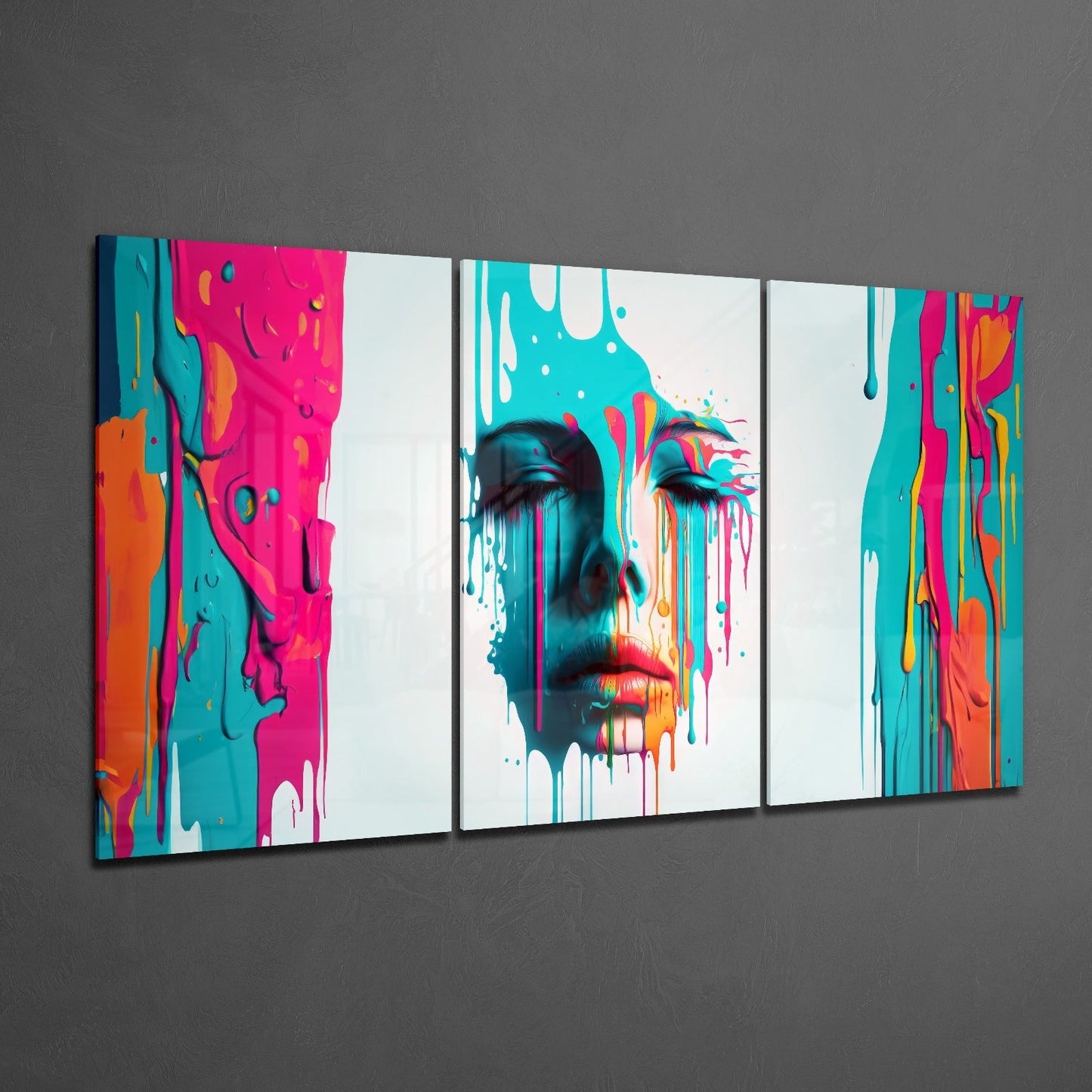 Three-panel glass wall art displaying a colorful abstract portrait with vibrant magenta, cyan, orange, and white paint drips against a gray wall.