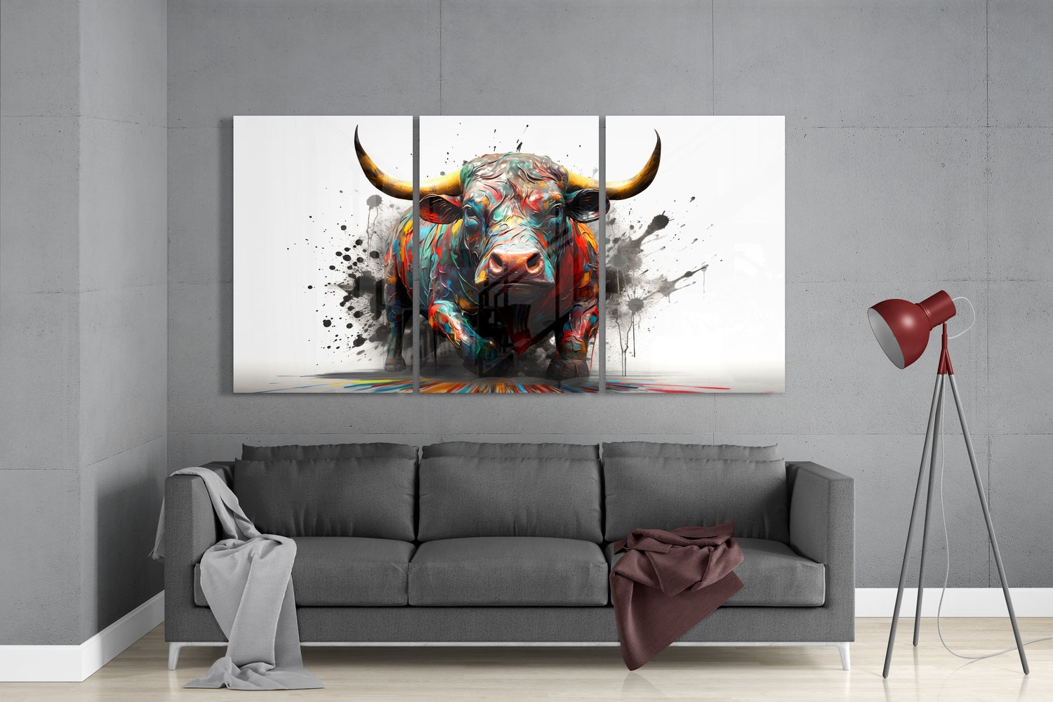 Colorful abstract bull artwork displayed as three-panel glass wall art above gray sofa in modern living room.