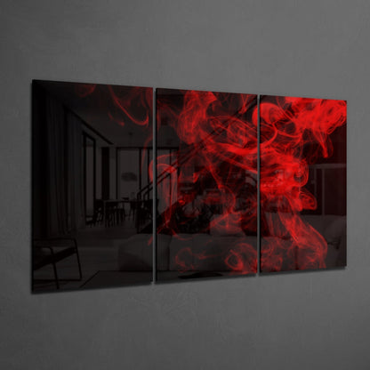 Three-panel red smoke glass wall art displayed at an angle against a gray wall, showing vibrant crimson swirls.