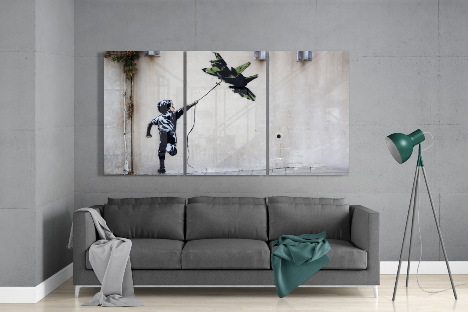 Multi-panel glass wall art depicting a child with a kite displayed above a gray sofa in a modern living room interior.