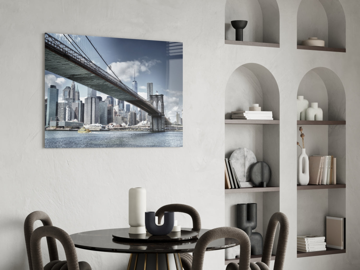 Manhattan Bridge glass wall art mounted above a round black dining table with upholstered chairs, displaying a photograph of the Brooklyn Bridge and New York City skyline.