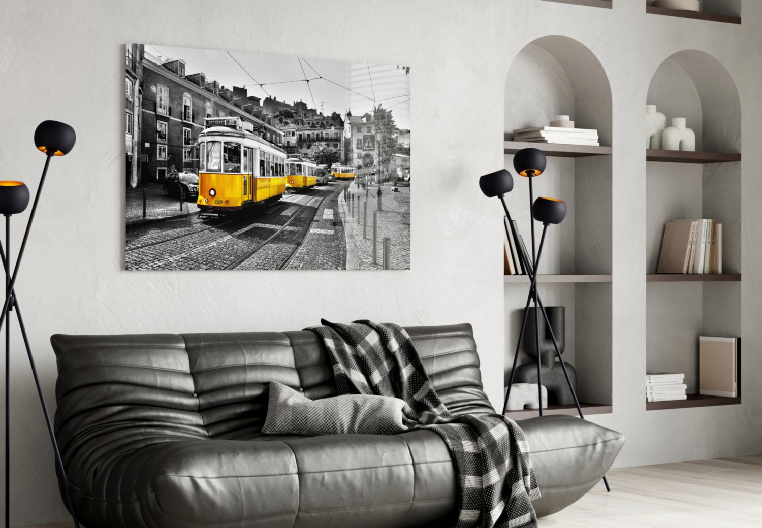 Yellow Tram glass wall art displayed above black leather sofa in modern living room with shelving unit.