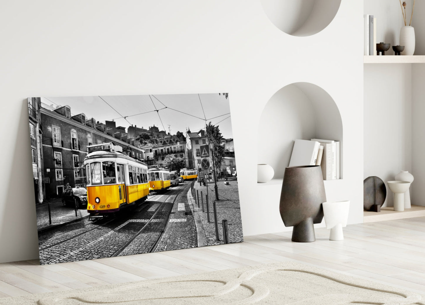 Yellow tram glass wall art leaning against white wall in minimalist room with neutral decor and sculptural objects.
