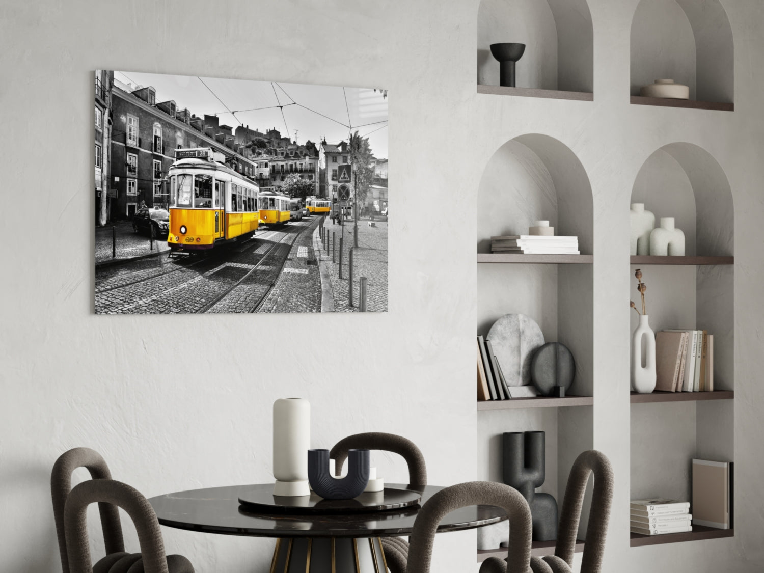 Yellow tram glass wall art displayed above a round black dining table in a modern interior with arched shelving.